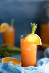 Fresh orange and carrot juice on blue background.