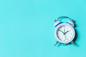 Simply minimal design ringing twin bell vintage classic alarm clock Isolated on blue pastel background. Rest hours time of life good morning night wake up awake concept. Flat lay top view, copy space