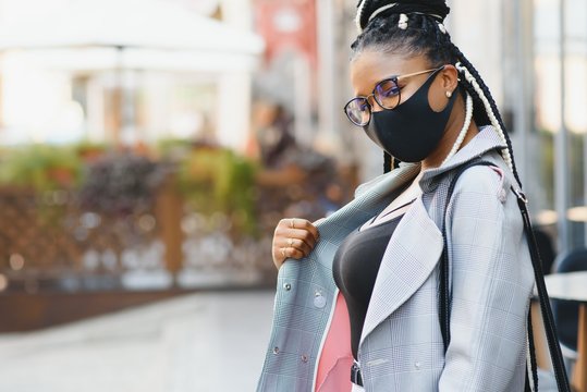 African american young volunteer woman wearing face mask outdoors. Coronavirus quarantine and global pandemic.
