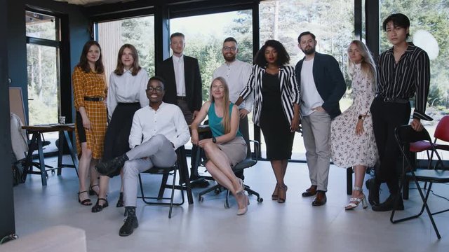 Big team portrait of happy young multiethnic business colleagues looking at camera posing for photo at modern office.