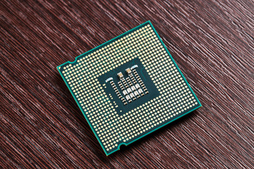 cpu processor hardware unit over wooden background. computer chip close up. digital industry concept