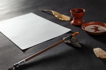 Calligraphy master work table with paper and pen