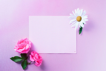 Empty gift card with flowers next to it, on top of colorful background. Mockup card design.