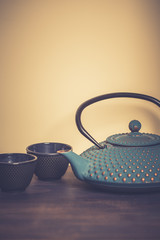 Traditional japanese herbal tea recipe prepared in cast iron teapot with organic dry herbs. Alternative medicine. Healthy asian green tea in tea pot on vintage wooden table background.