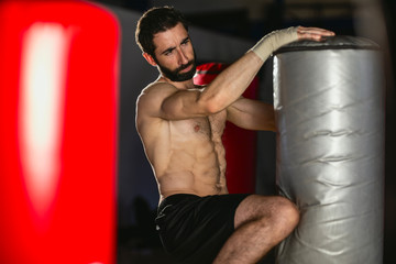 Kickboxer trains by kicking on the boxing bag.