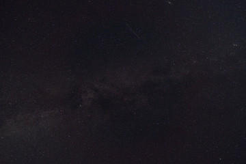 black night sky and stars as background, the milky way and falling Perseid meteors