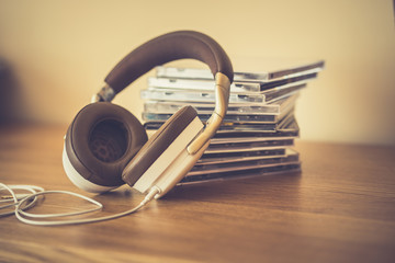 Stereo headphone and compact discs on wooden background