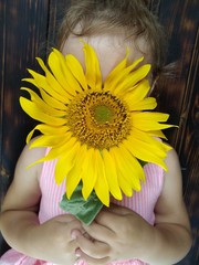 girl with sunflower on a wood table