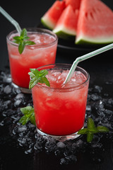 Summer cold drink with watermelon and mint on a black wooden background.