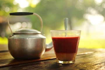 Hot milk tea is placed on a wooden table in the garden. Sense the focus.