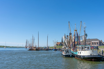 Empty sailboats and pleasure craft are anchored in the water