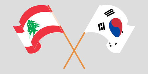 Crossed and waving flags of Lebanon and South Korea