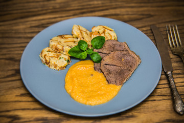 Beef slices with dumplings and mashed potatoes on plates. The food in the restaurant. Food styling and restaurant meal serving.