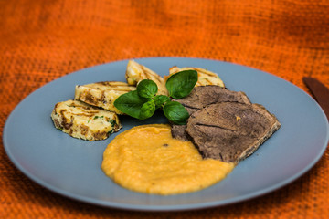 Beef slices with dumplings and mashed potatoes on plates. The food in the restaurant. Food styling and restaurant meal serving.
