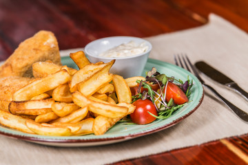French fries with cheese and vegetables. The food in the restaurant. Food styling and restaurant meal serving.