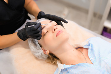 Beautician using acne removal cosmetic spoon in a beauty salon