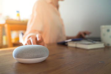 Smart ai voice speaker with woman in background.