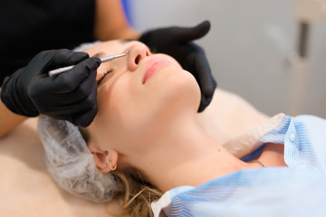 Beautician using acne removal cosmetic spoon in a beauty salon