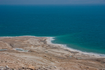 
Panoramic view of the coast of the Dead Sea in Israel with a salt border on the shore.