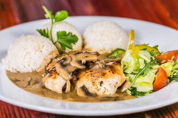 Chicken breast on mushroom sauce with rice. The food in the restaurant. Food styling and restaurant meal serving.