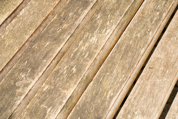 Natural wood flooring outdoors. Diagonal light dirty boards with slots