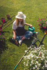 Gardening  Gardener Girl Relaxed Lying  Green Grass, Surrounded Gardening Tools With Plants Workplace home among plants  home garden ,agriculture, freelance, work  home, slow life, mood