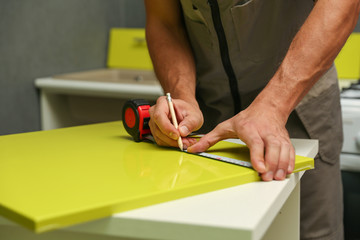 assembly of kitchen furniture. furniture handle installation close up. 