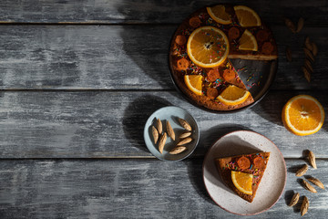 Orange cake on a gray wooden background. Hard light. Top view, copy space.