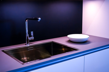 Dark marble wash basin with glossy metal mixer. Colored backlight. white plates. High quality photo