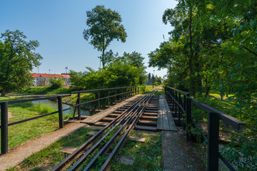 A drive across the Gasawka river for the narrow-gauge railway in the city of Żnin on a beautiful sunny day with a blue cloudless sky.