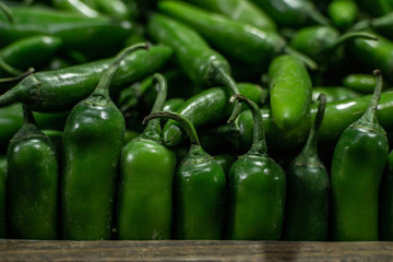 green serrano chili peppers at a market stall