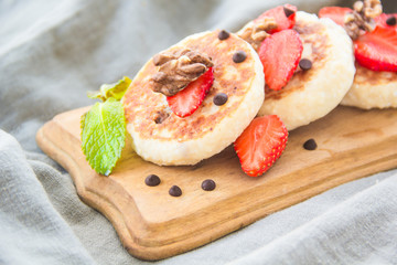 A healthy breakfast of pancakes, strawberries, chocolate, and honey