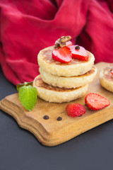 A healthy breakfast of pancakes, strawberries, chocolate, and honey