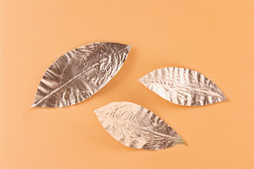 Leaves painted in gold on an orange background.