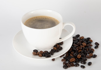 Coffee cup and coffee beans on fabric background.