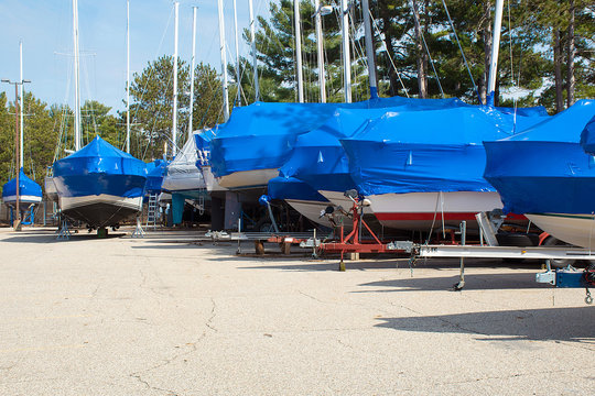 Protective Blue Tarp On Boats In Michigan Outdoor Storage Lot