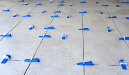 Industrial background. Tile leveling system with plastic clips and wedges, 
