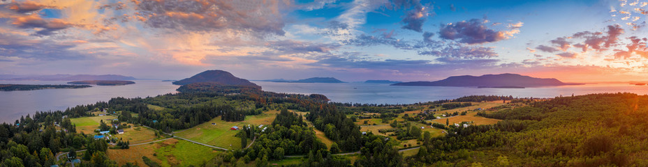 Aerial Panoramic View of a Lummi Island Sunset. Pastureland reflects a rural character to the...