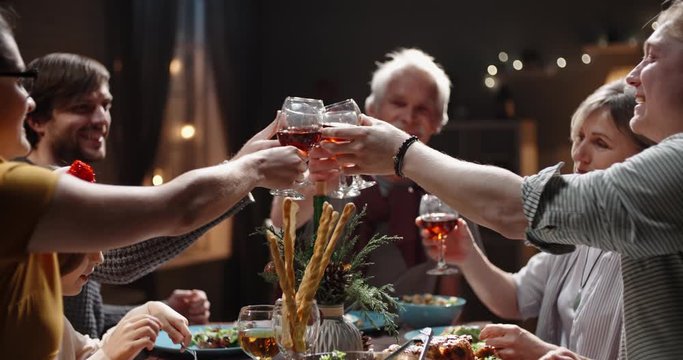People celebrating christmas at home. Large caucasian family making a toast and clinking their glasses, positively smiling - celebration concept 4k footage