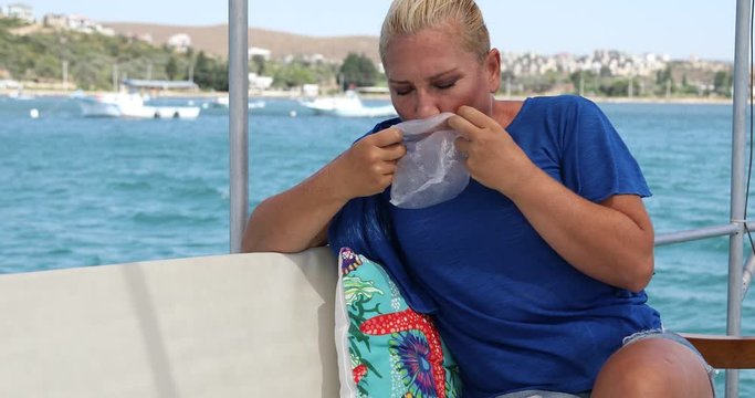 Middle aged woman having a nausea sea sickness during the boat trip