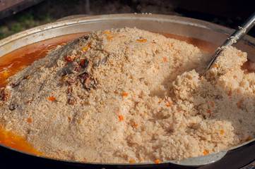 Uzbek pilaf in a large cauldron. Cooking a national Uzbek dish. National cuisine of the peoples of the world.