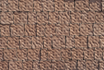 Cobblestone texture. The sidewalk tile is evenly folded. Brown cobblestones close up.