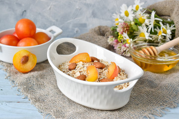 Oatmeal with almonds and apricots on a white plate