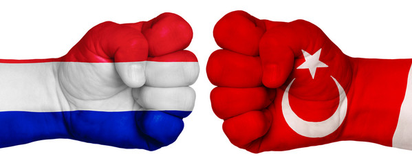 Two hands are clenched into fists and are located opposite each other. Hands painted in the colors of the flags of the countries. France vs Turkey