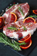 Raw meat steaks with rosemary and spices on a stone board. Keto. Paleo. Pegan diet.