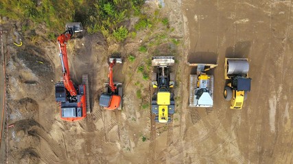 Baumaschinen (Bagger, Radlader, Walze, Planierraupe) auf einer Baustelle aus der Vogelperspektive  © keBu.Medien
