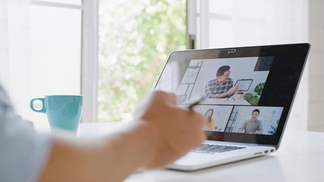 Asian man video call conference, online remote meeting with business coworker, at home. New normal lifestyle, social distancing, internet technology, businessman work from home concept