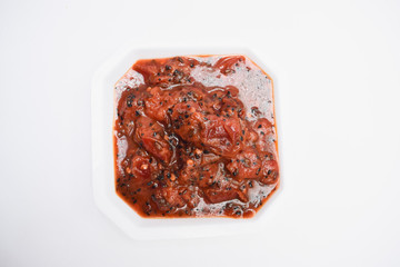 Plum chutney sweet and tangy indian chutney with little spice from tempered tadka in white background decprated with money plant and hibiscus red flower. Alu bukhare ki tasty chutney