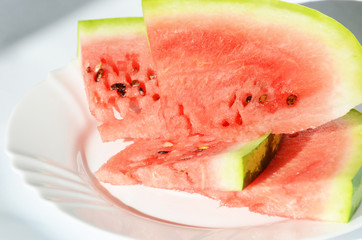 Ripe watermelon pieces on the plate isolated on white, delicious berry