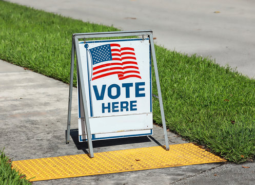 Vote Here Sign placed on the walkway to a neighborhood polling place, as seen on election day in Fort Lauderdale, Florida, USA.